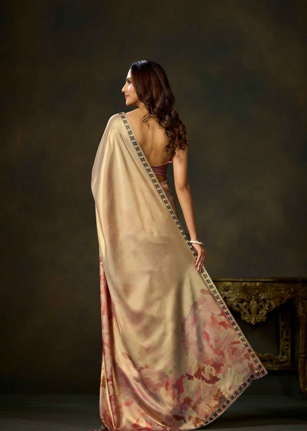 Back view of pink watercolor printed satin silk saree with flowing pallu and patterned border.