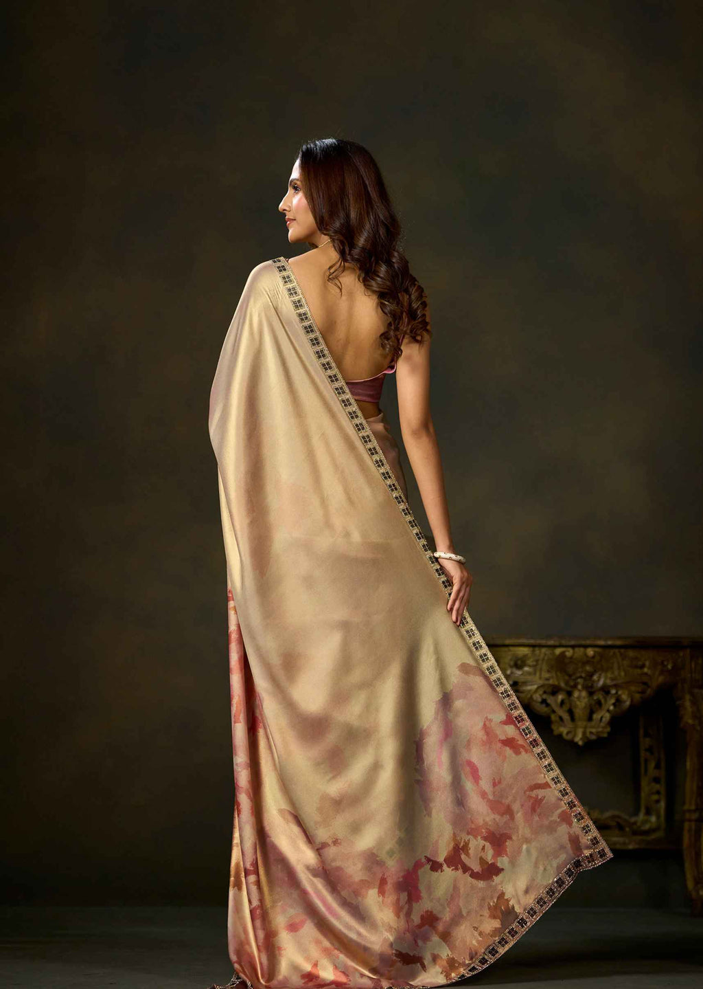 Back view of pink watercolor printed satin silk saree with flowing pallu and patterned border.
