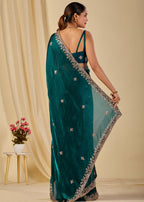 Teal green designer organza saree with shimmering floral motifs