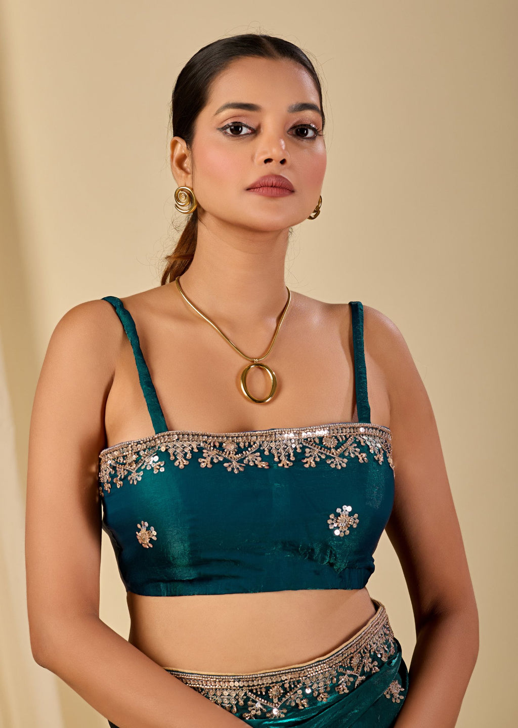 Teal organza saree styled with embroidered blouse and shimmering floral accents