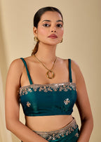 Teal organza saree styled with embroidered blouse and shimmering floral accents