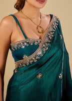 Teal green party wear organza saree with floral motifs and sheer pallu
