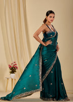 Elegant teal organza saree with detailed silver and gold embroidered border