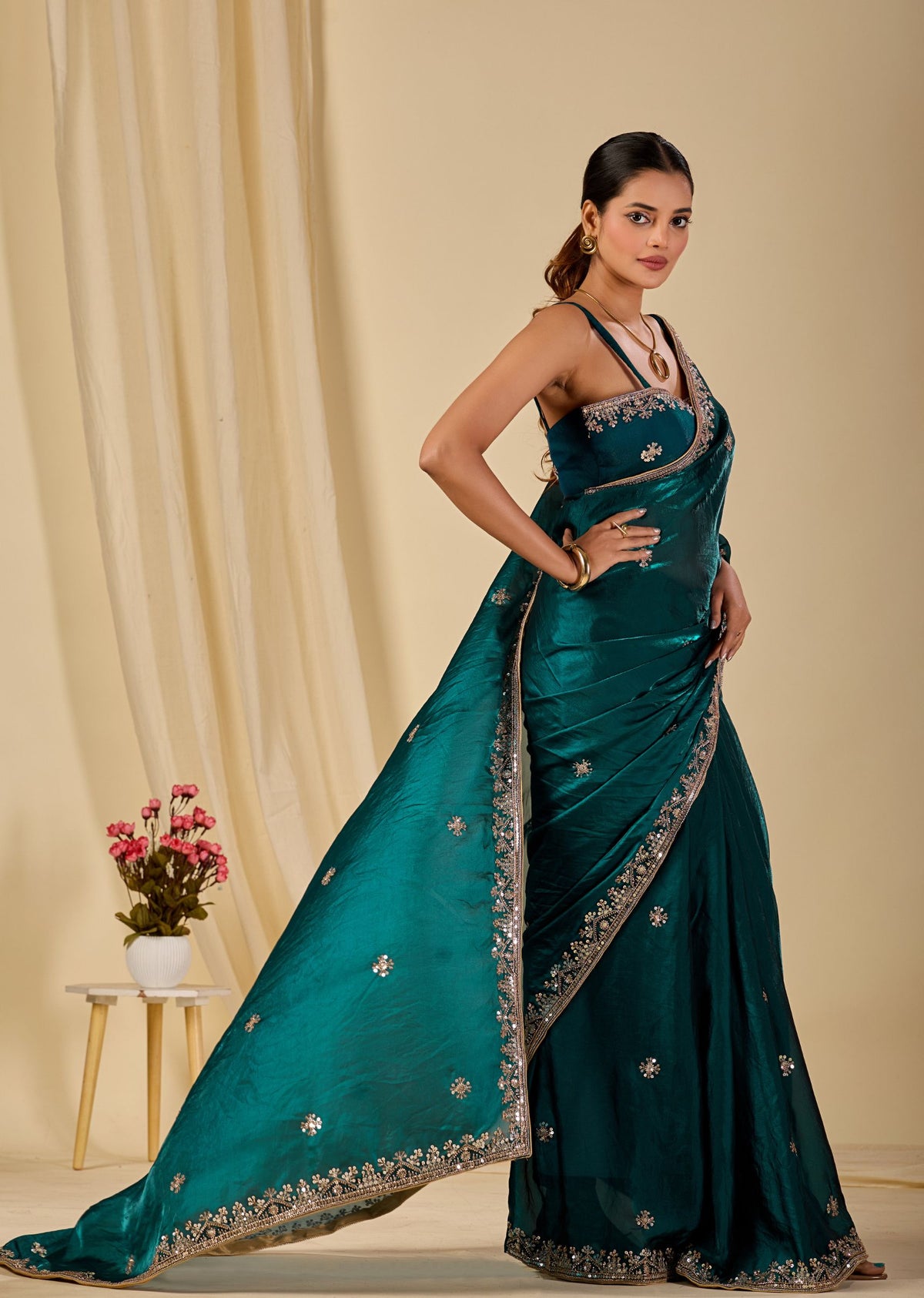 Elegant teal organza saree with detailed silver and gold embroidered border