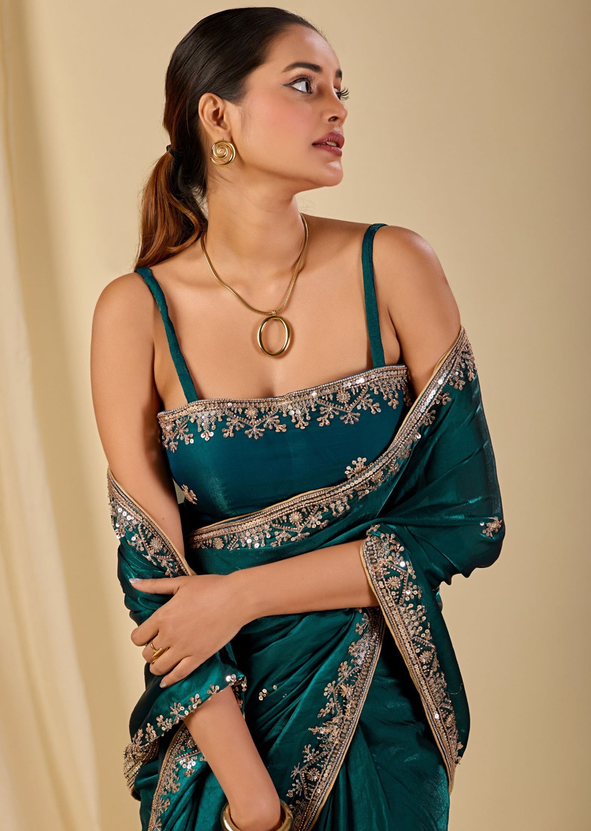 Teal green festive saree featuring delicate sequin floral embellishments