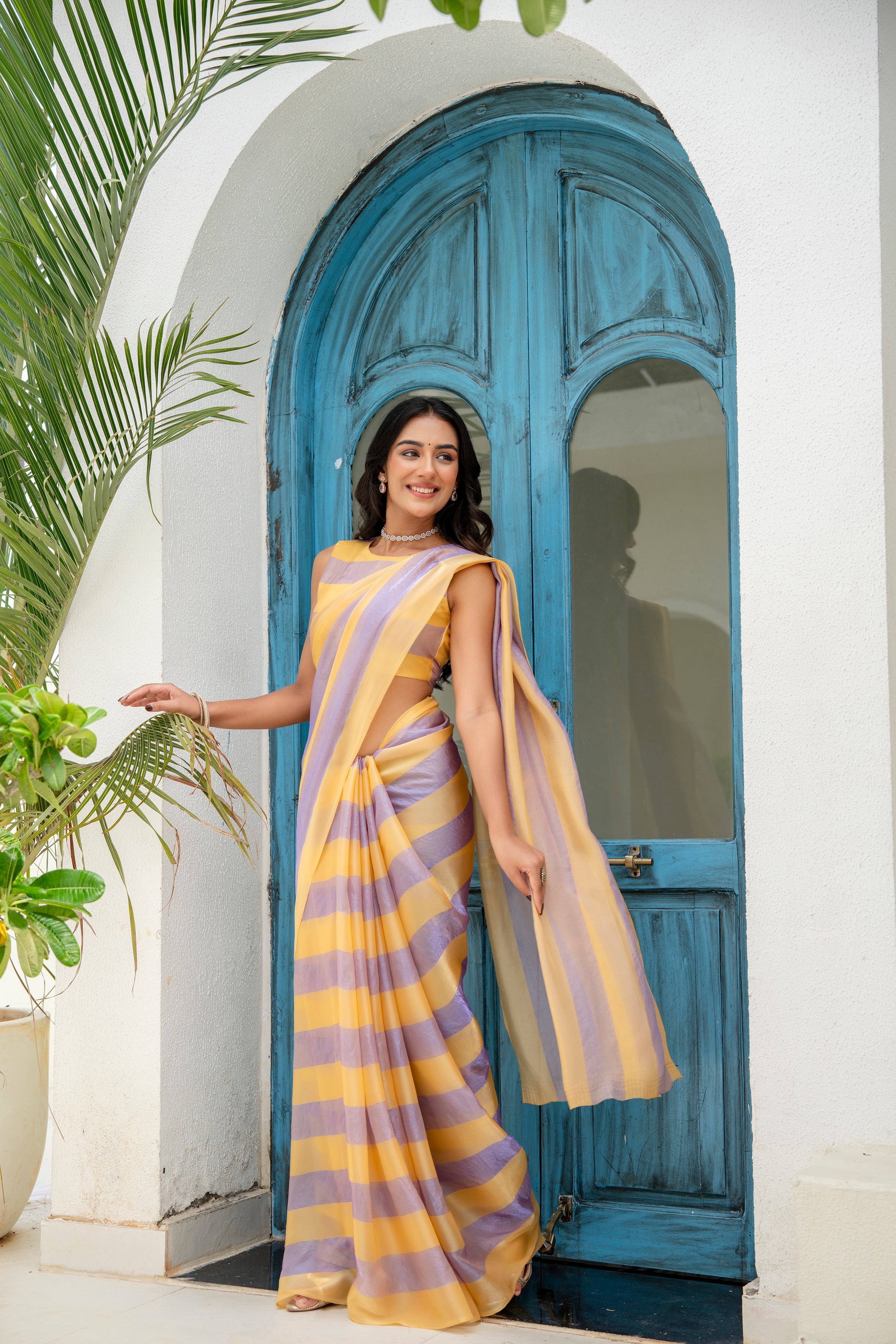 A woman wearing a yellow and lavender striped saree 